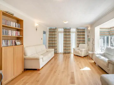 a living room with white furniture and a book shelf at Tigh Na Beannaich in Powmill