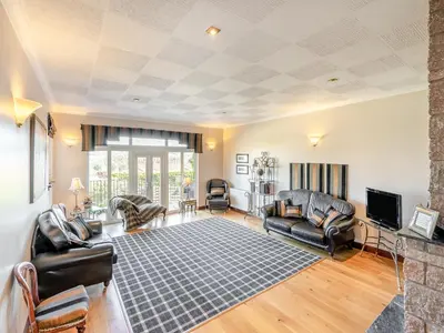 a living room with leather furniture and a tv at Tigh Na Beannaich in Powmill