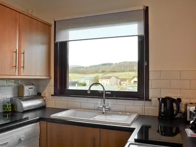 a kitchen with a sink and a window at Gean Cottage in Powmill