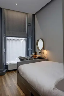 a bedroom with a bed and a mirror and a window at Bruntsfield Hotel in Edinburgh