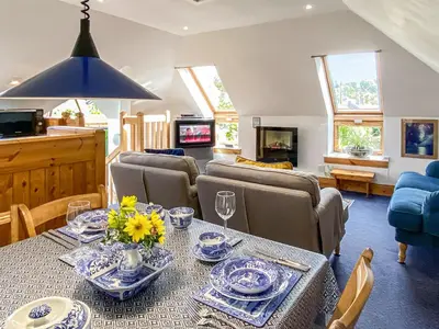 a living room with a table and a couch at Garden Cottage in Linlithgow