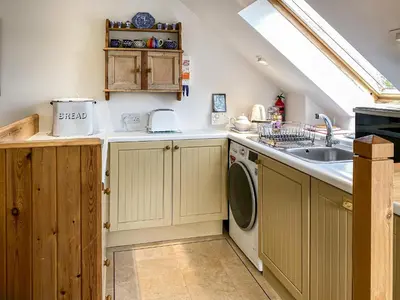 a kitchen with a sink and a washing machine at Garden Cottage in Linlithgow