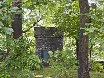 an old stone tower in the middle of trees at Coach House in Ratho