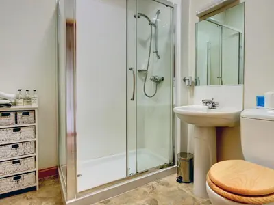 a bathroom with a shower and a toilet and a sink at Coach House in Ratho
