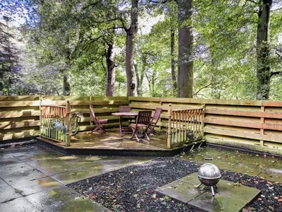 a patio with two chairs and a table and a fence at Coach House in Ratho