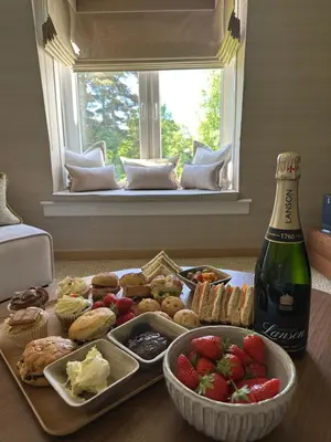 a table with a tray of food and a bottle of wine at Gleneagles Holiday Home Rental in Auchterarder