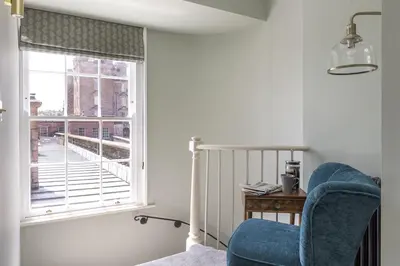 a room with a blue chair and a window at East Wing in Thornhill