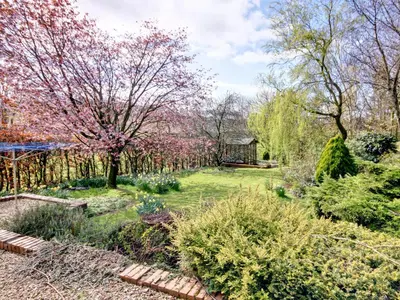 a garden with flowering trees and a house at The Cottage in Girvan