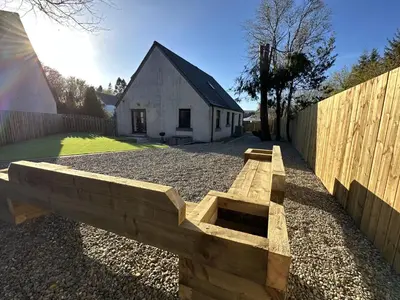 a wooden bench in front of a fence at Lochindaal - Beautiful, Spacious 4 Bedroom House in Kintyre in Whitehouse