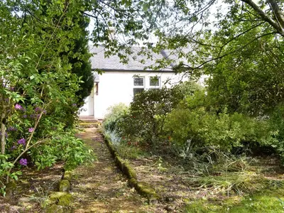 a garden path leading to a white garage at Blairhosh Cottage in Balloch