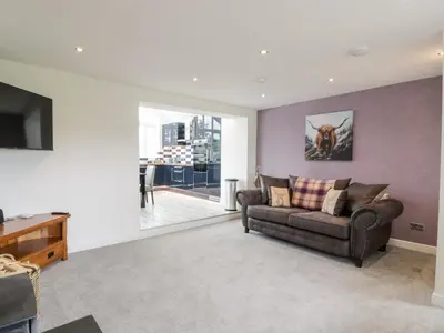 a living room with a couch and a tv at Braeface Cottage in Bonnybridge