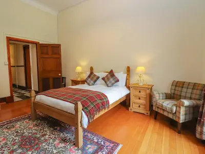 a bedroom with a bed and a couch and a chair at Rob Roy Apartment in Stirling