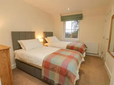 two twin beds in a room with a window at Taigh Geal in Killin