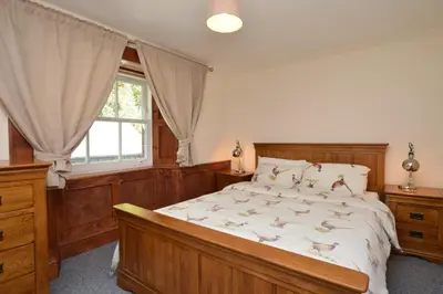 a bedroom with a large bed and a window at Eckford House in Dunoon