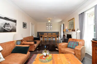 a living room with leather furniture and a table at Eckford House in Dunoon