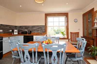 a kitchen and dining room with a table and chairs at Eckford House in Dunoon