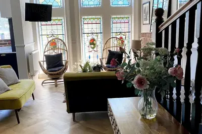 a living room with a couch and stained glass windows at Stunning 3 bedroom Victorian home near Pollok country park in Glasgow