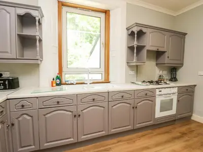 a kitchen with gray cabinets and a window at Mars Hill Upper in Dunoon