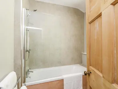 a bathroom with a shower and a white bath tub at Mars Hill Upper in Dunoon