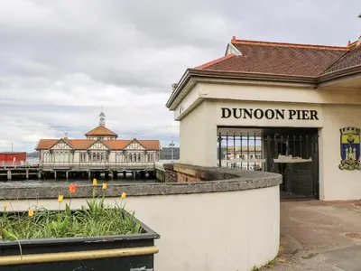 a building with a dunedin pier in the background at Mars Hill Upper in Dunoon