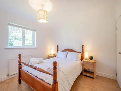 a bedroom with a large bed and a window at Seamill Cottage in Seamill