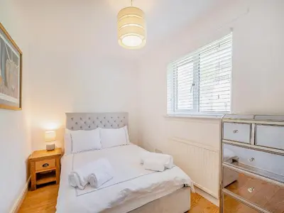 a small bedroom with a bed and a window at Seamill Cottage in Seamill
