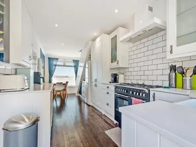 a kitchen with white cabinets and a counter top at Aird Cottage in Dunure