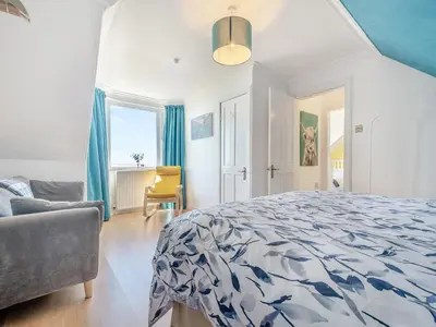 a bedroom with a bed and a couch and a chair at Aird Cottage in Dunure