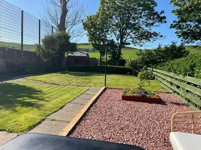 a garden with a fence and a flower bed at Southend, Mull of Kintyre, Campbeltown in Campbeltown