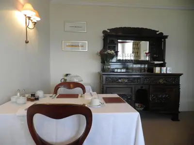 a room with a table with two chairs and a mirror at Douglas Park Guest House in Dunoon