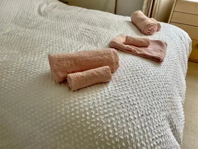 two towels on top of a white bed at Bayside - Breathtaking views of the Clyde in Rothesay