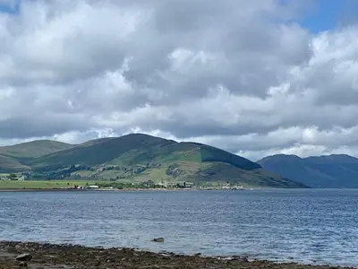 a large body of water with mountains in the background at Bayside - Breathtaking views of the Clyde in Rothesay