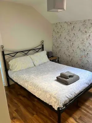 a bed with two towels on it in a bedroom at The Villas in Helensburgh