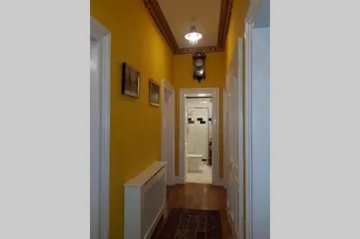 a hallway with a yellow wall and a white doorway at Snug - Fountain Bank Apartment in Helensburgh