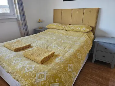 a bedroom with a bed with two pillows on it at Snug - Colquhoun Square Apartment in Helensburgh
