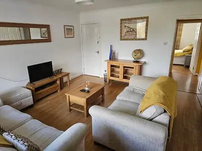 a living room with two couches and a tv at Snug - Colquhoun Square Apartment in Helensburgh