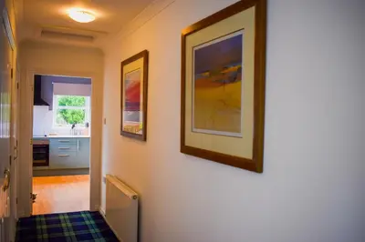a hallway with two pictures on the wall at Heatherbank Cottage in Onich