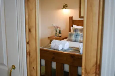 a bedroom with a bed with towels on it at Heatherbank Cottage in Onich