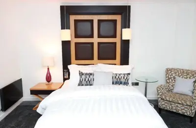 a bedroom with a large white bed and a chair at Maltings Hotel in Dunfermline