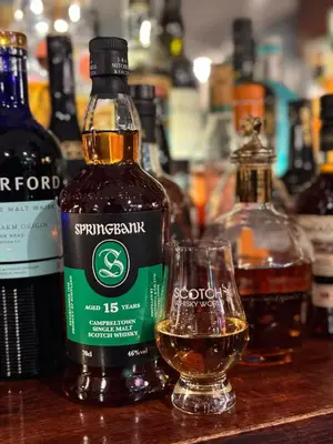 a bottle of whisky and a glass on a table at Maltings Hotel in Dunfermline