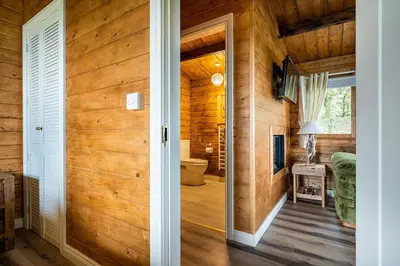 a door leading into a bathroom with wooden walls at Torr Lodge- luxury log cabin with private hot tub! in Ballycastle