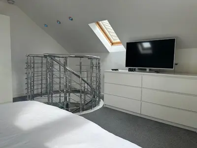 a bedroom with a tv on top of a dresser at Seaside Home in Ardeer Square