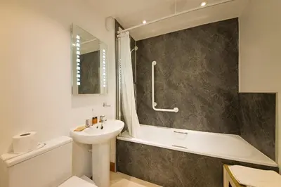 a bathroom with a sink and a toilet and a tub and a sink at Falls of Lora Hotel in Oban