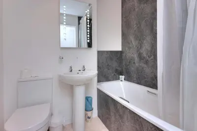 a white bathroom with a sink and a tub and a toilet at Falls of Lora Hotel in Oban