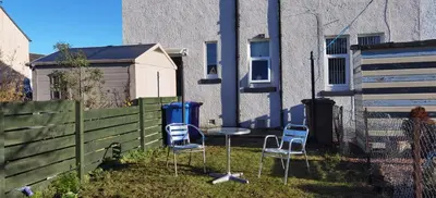two chairs and a table in front of a building at Parkside 2 bedrooms appartment with encolsed garden in Largs