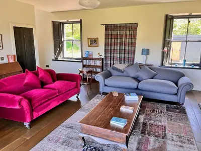 a living room with two couches and a coffee table at Railway Cottage in Killin