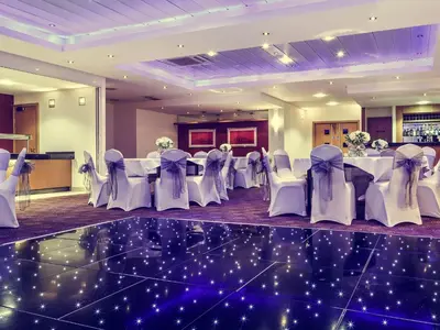 a set of tables and chairs in a room at Mercure Glasgow City Hotel in Glasgow