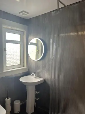 a bathroom with a sink and a mirror at Loch Lomond Apartment in Alexandria