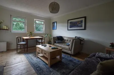 a living room with a couch and a table at Loch Lomond Apartment in Alexandria