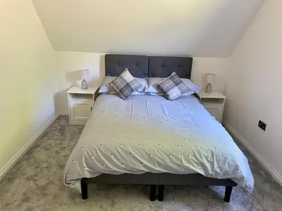 a bedroom with a bed with two night stands at Còsagach Flat near Oban in Barcaldine